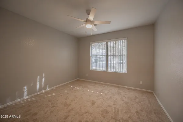 an empty room with closet and a chandelier fan