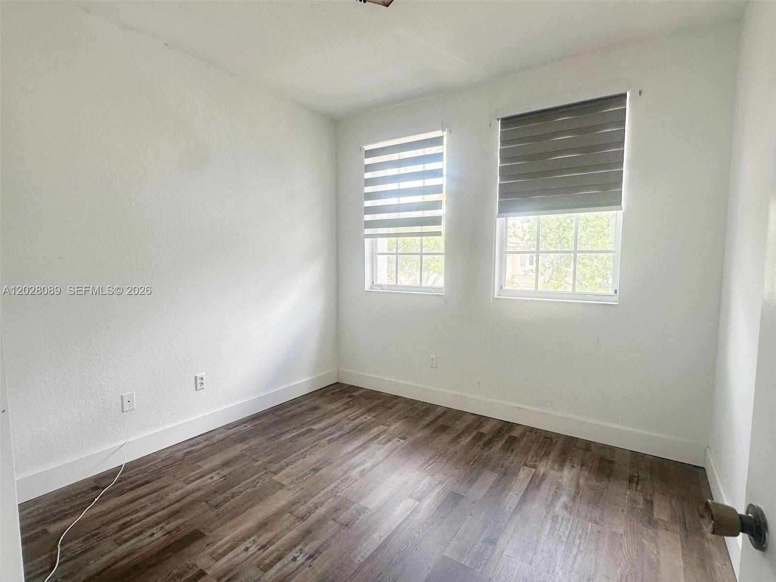 662 Northeast 21st Terrace Homestead, FL 33033 - Photo 18 of 34 an empty room with wooden floor and windows