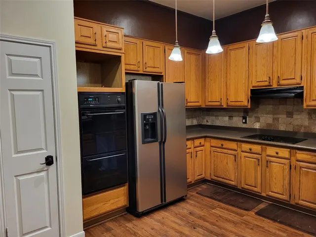 a kitchen with stainless steel appliances a refrigerator a sink and white cabinets