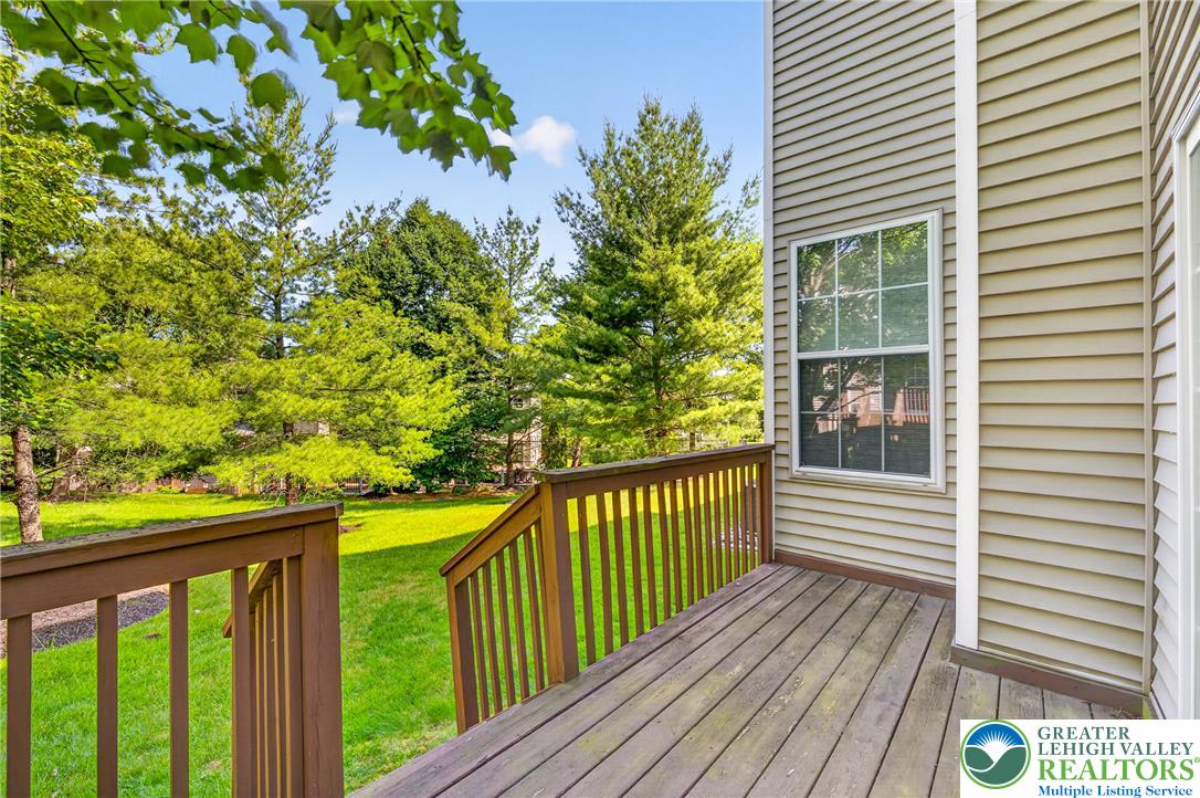4345 Creek Road Allentown, PA 18104 - Photo 29 of 33 A well-maintained wooden deck extends to a lush green yard, framed by mature trees.