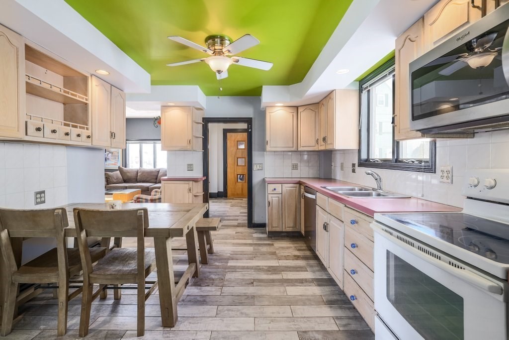 33 Montrose Street Everett, MA 02149 - Photo 7 of 36 a kitchen with stainless steel appliances a table chairs sink and cabinets