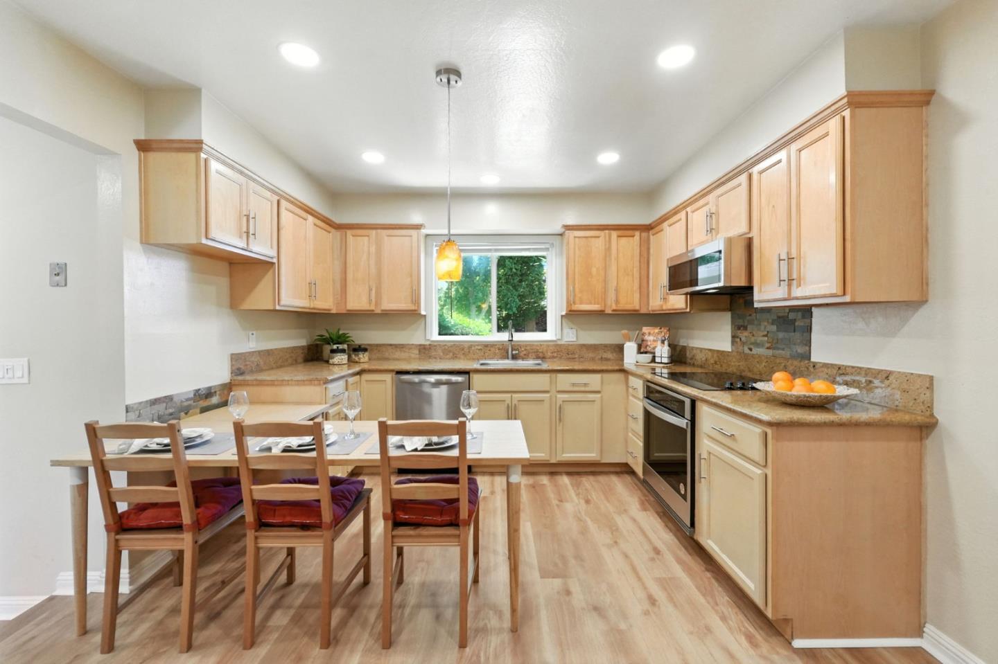 479 Chestnut Avenue Milpitas, CA 95035 - Photo 12 of 27 a kitchen with stainless steel appliances granite countertop a stove top oven a sink dishwasher a dining table and chairs with wooden floor