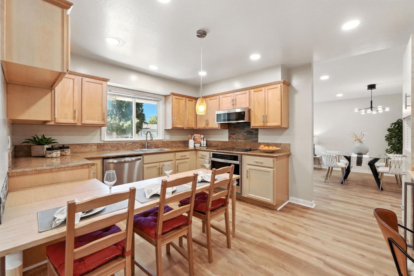 479 Chestnut Avenue Milpitas, CA 95035 - Photo 13 of 27 a kitchen with kitchen island granite countertop wooden floors and white cabinets