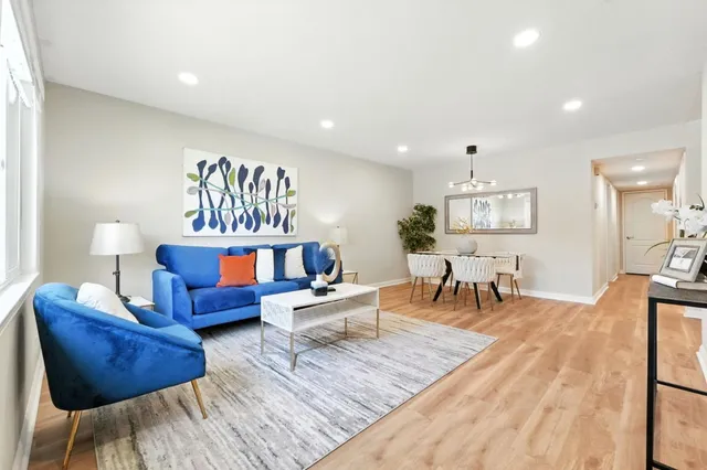 a living room with furniture a window and a chandelier