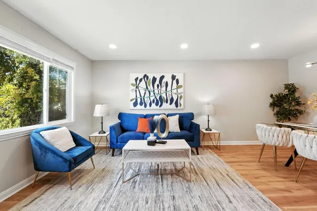 a living room with furniture and a dining table with wooden floor