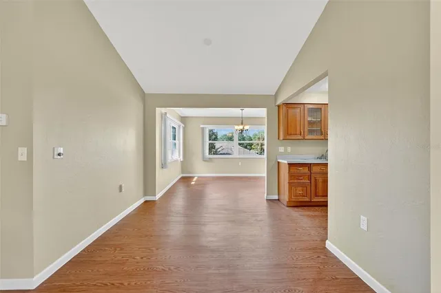a view of a kitchen with furniture a ceiling fan and wooden floor