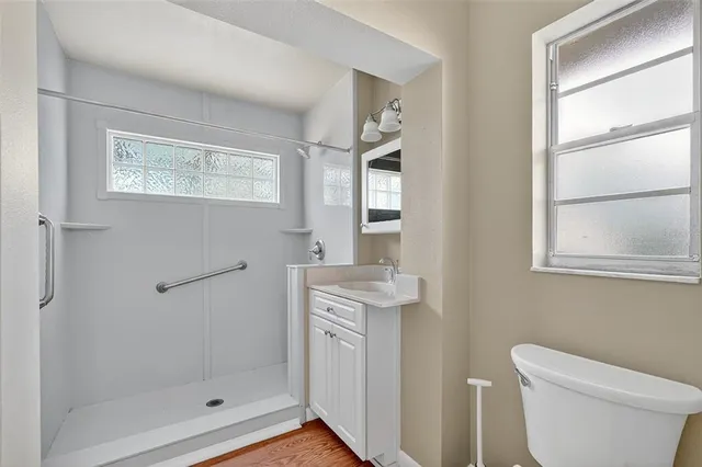 a bathroom with a granite countertop toilet sink and mirror