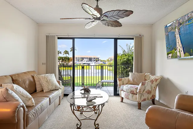 a living room with furniture and a large window with garden view