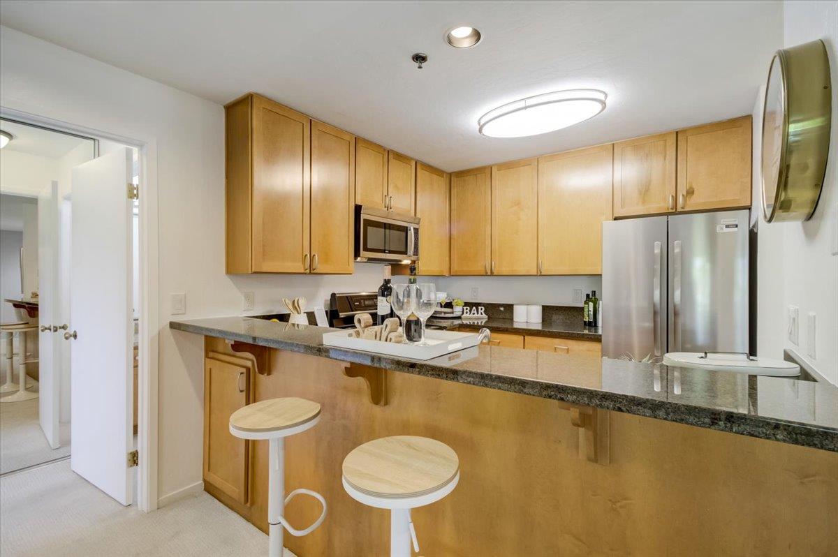 300 Murchison Drive, Unit 311 Millbrae, CA 94030 - Photo 4 of 25 a kitchen with sink a refrigerator and chairs