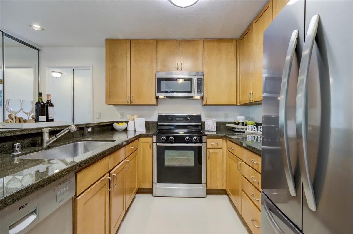 300 Murchison Drive, Unit 311 Millbrae, CA 94030 - Photo 5 of 25 a kitchen with stainless steel appliances granite countertop a stove a sink and a refrigerator