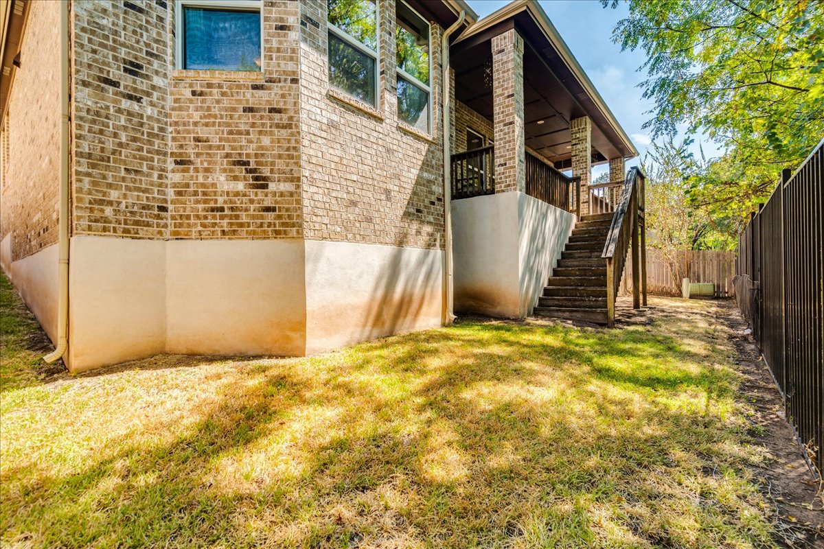 12909 Medina River Way Austin, TX 78732 - Photo 35 of 36 Stately brick construction frames a multi-level back elevation with elevated porch structures.