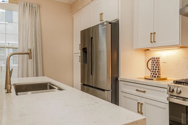a kitchen with stainless steel appliances a refrigerator sink and cabinets