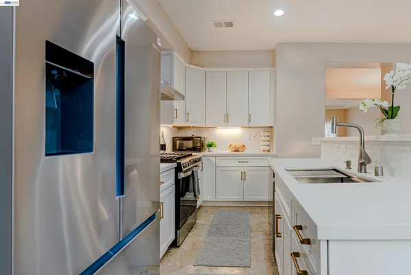 a kitchen with granite countertop white cabinets and appliances