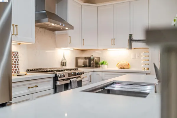 a kitchen with granite countertop white cabinets stainless steel appliances and sink