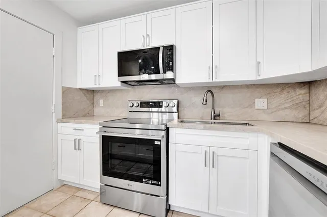 a kitchen with white cabinets stainless steel appliances and sink