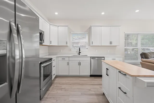 a kitchen with white cabinets stainless steel appliances and sink
