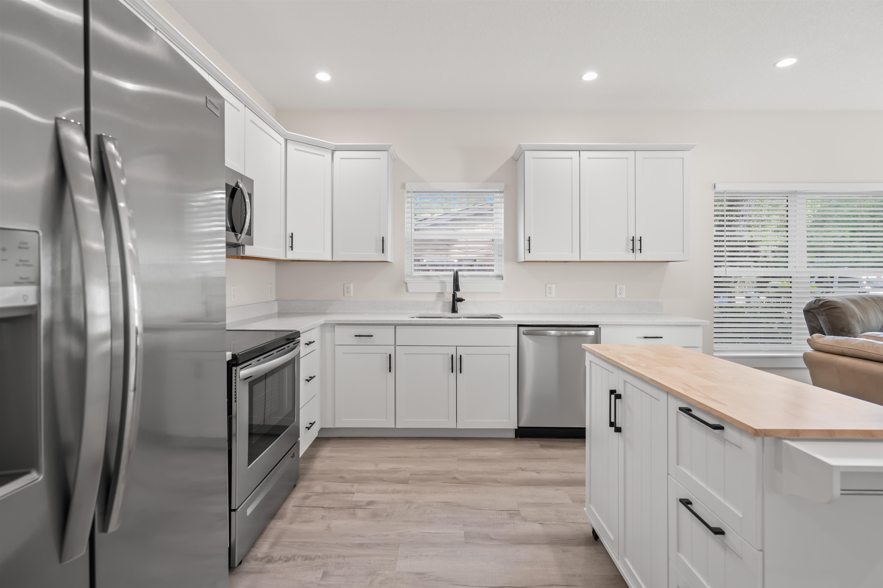 141 Webb Street St. Augustine, FL 32084 - Photo 11 of 33 a kitchen with white cabinets stainless steel appliances and sink