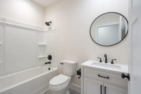 a bathroom with a toilet a sink a mirror and tub