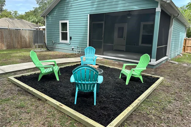 a view of a chair and table in backyard of the house