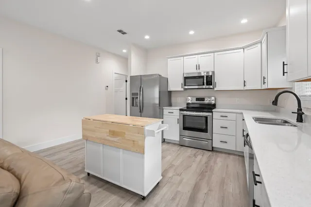 a kitchen with white cabinets and stainless steel appliances