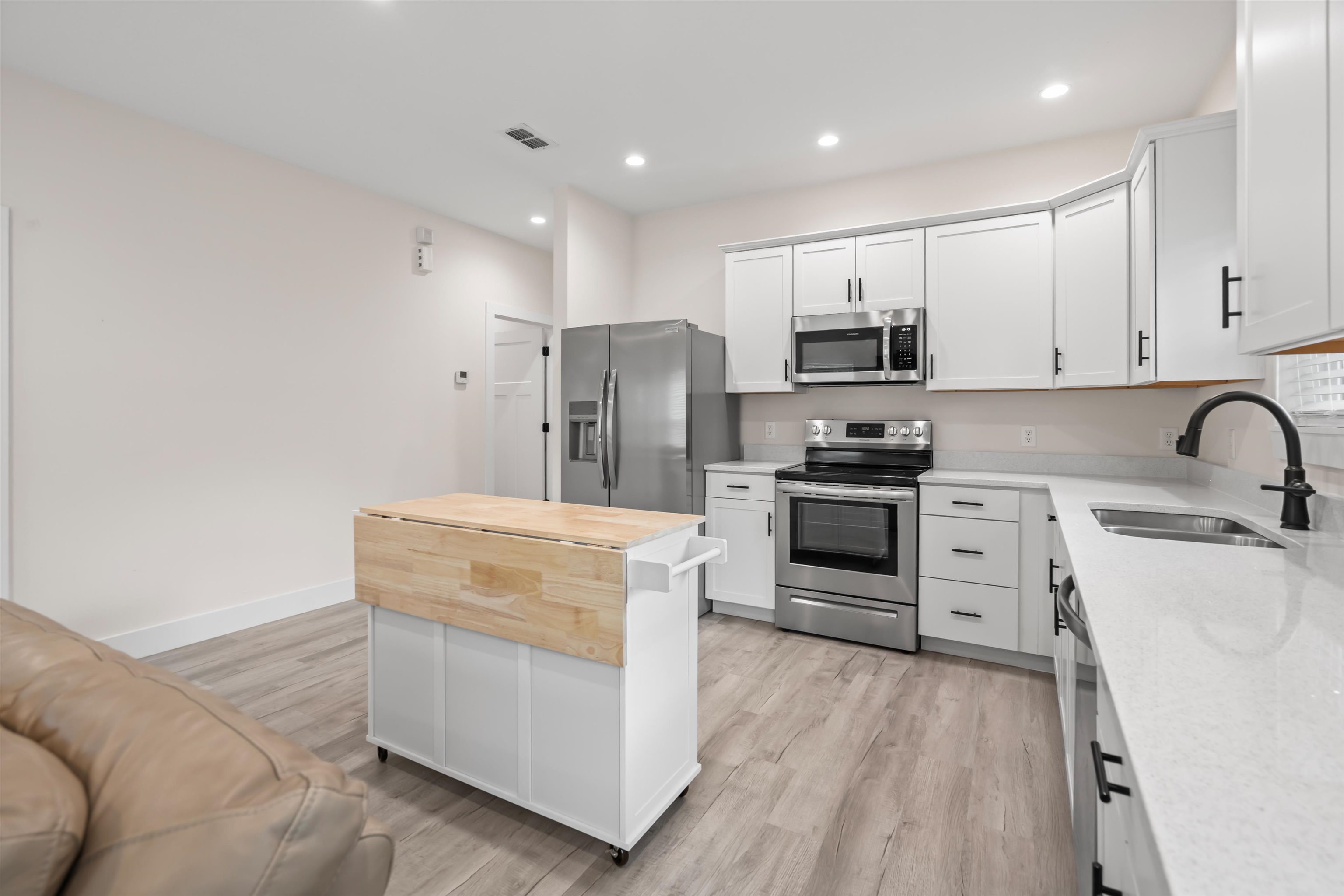 141 Webb Street St. Augustine, FL 32084 - Photo 8 of 33 a kitchen with white cabinets and stainless steel appliances