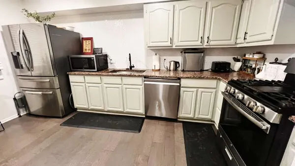 a kitchen with stainless steel appliances granite countertop a refrigerator sink and stove