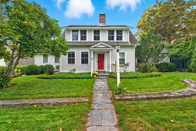 a front view of a house with a yard and potted plants
