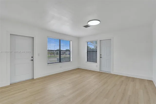 wooden floor in an empty room with a window