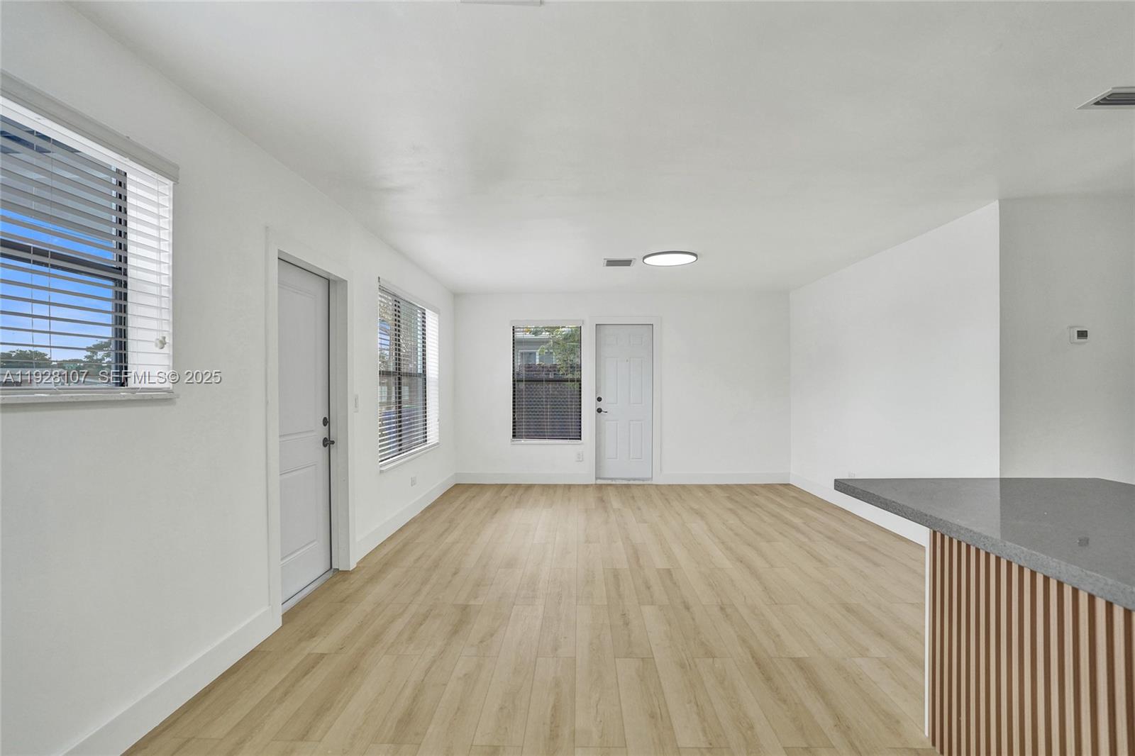 1960 Southwest 68th Way Miramar, FL 33023 - Photo 13 of 42 a view of an empty room with wooden floor and a window