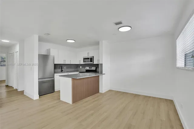 a kitchen with stainless steel appliances granite countertop a refrigerator and a stove top oven