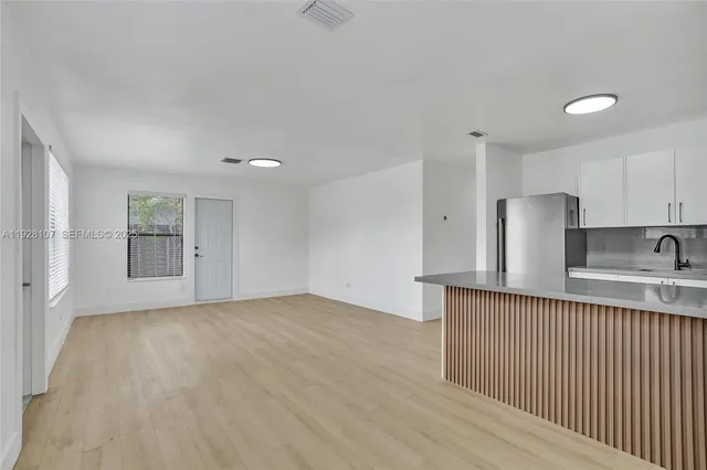 a view of kitchen with stainless steel appliances granite countertop a sink and cabinets