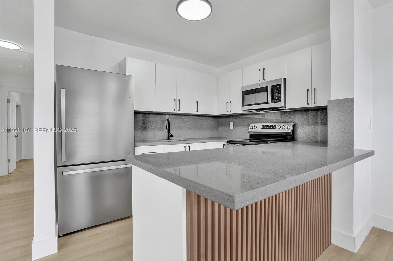 1960 Southwest 68th Way Miramar, FL 33023 - Photo 18 of 42 a kitchen with stainless steel appliances granite countertop a refrigerator a sink a stove a microwave and white cabinets