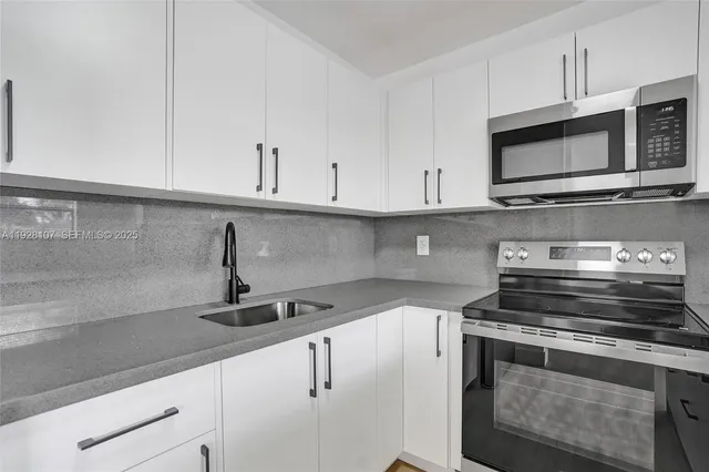 a kitchen with appliances a sink and cabinets