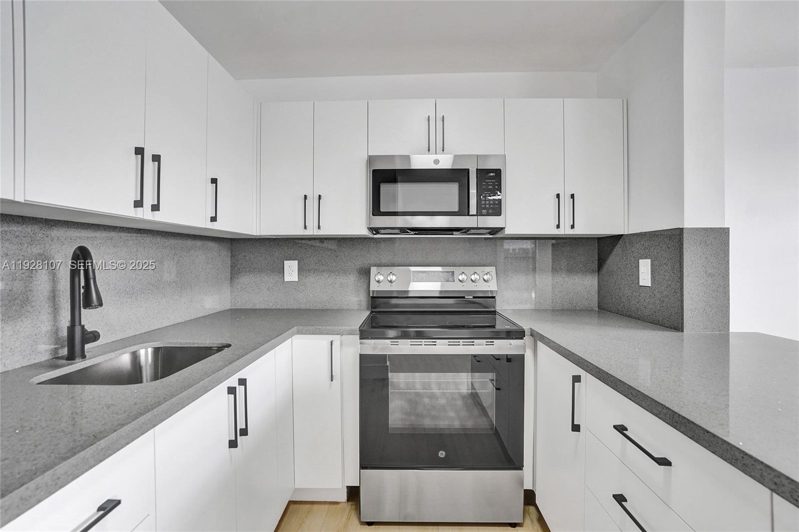 1960 Southwest 68th Way Miramar, FL 33023 - Photo 22 of 42 a kitchen with cabinets appliances a sink and a counter top