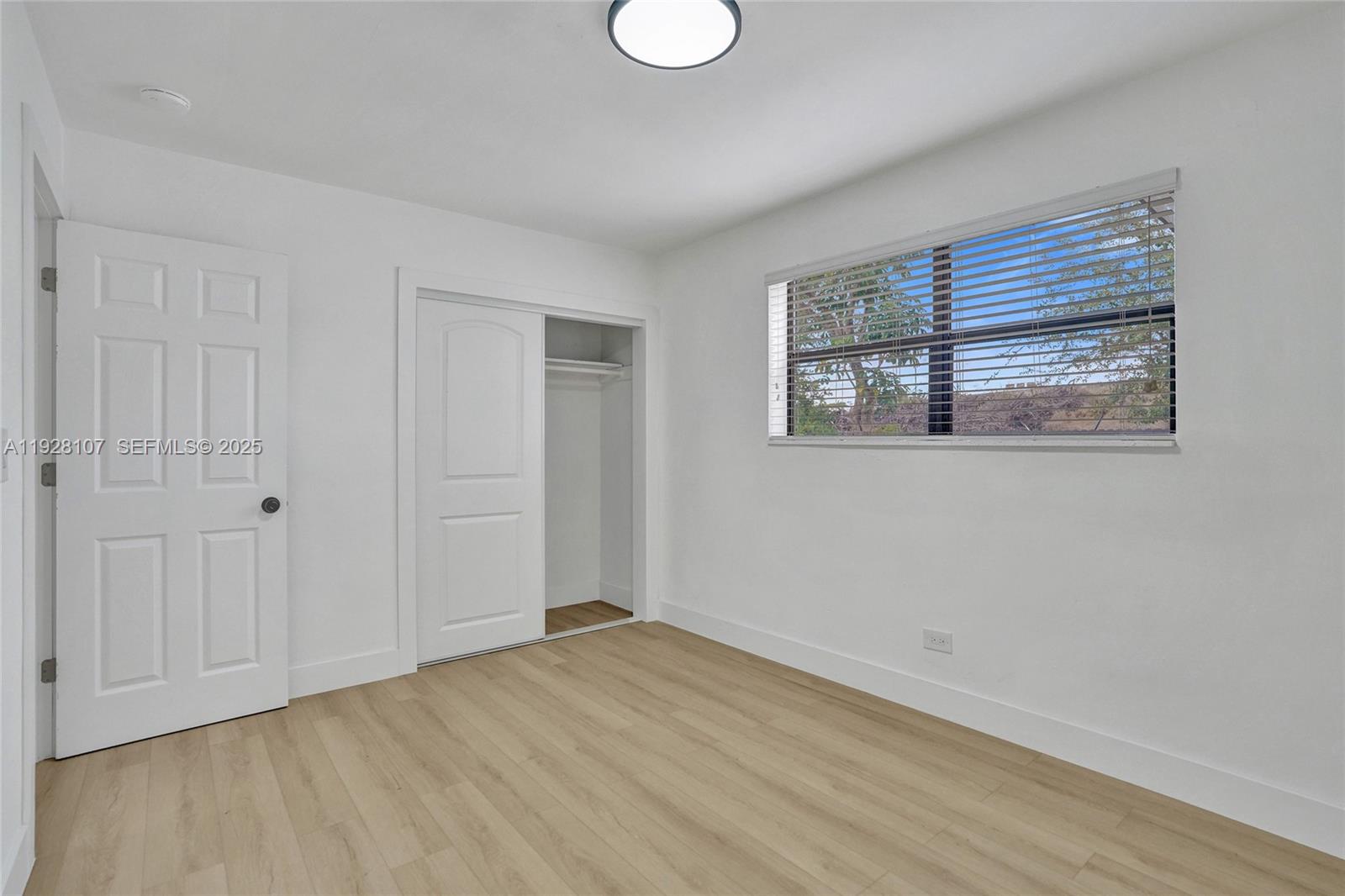 1960 Southwest 68th Way Miramar, FL 33023 - Photo 29 of 42 a view of an empty room with wooden floor and a window