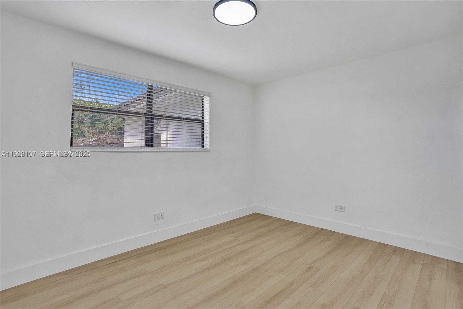 1960 Southwest 68th Way Miramar, FL 33023 - Photo 30 of 42 a view of an empty room with wooden floor and a window