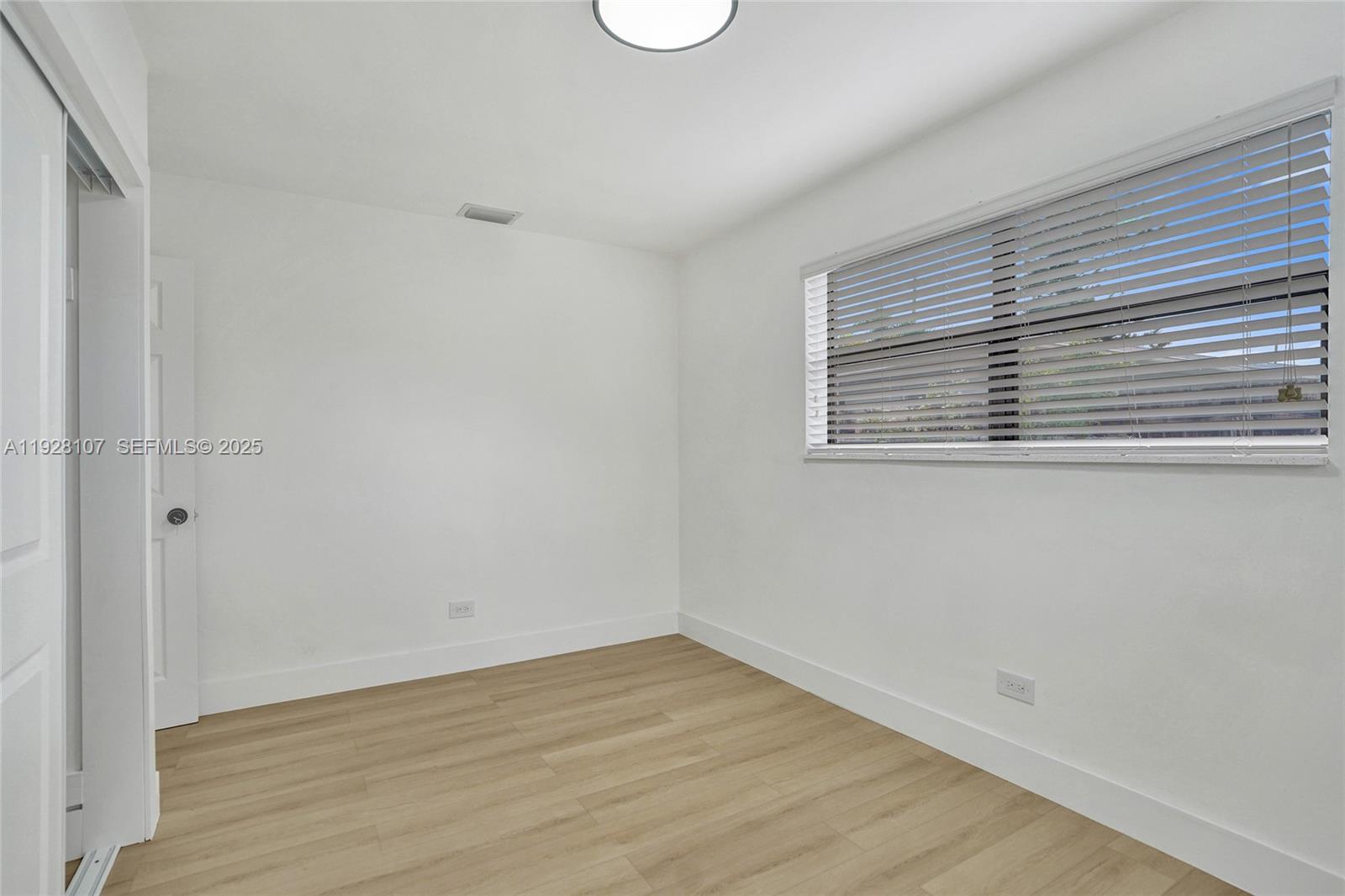 1960 Southwest 68th Way Miramar, FL 33023 - Photo 31 of 42 a view of an empty room with wooden floor and a window