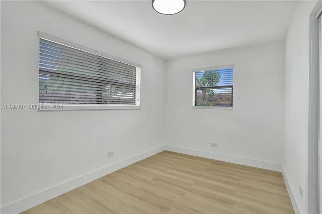 a view of a room that has wooden floor and cabinets