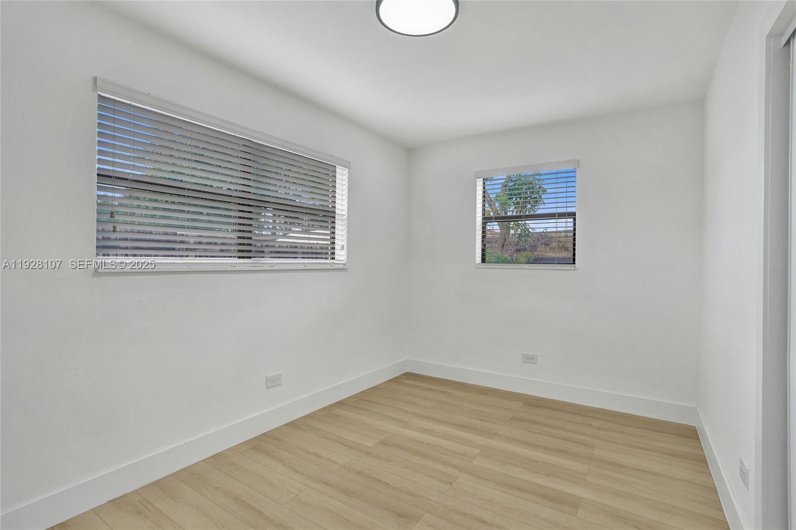 1960 Southwest 68th Way Miramar, FL 33023 - Photo 34 of 42 a view of an empty room with wooden floor and a window