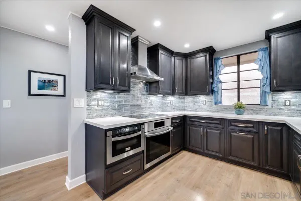 a kitchen with stainless steel appliances granite countertop wooden cabinets a stove a sink and a window