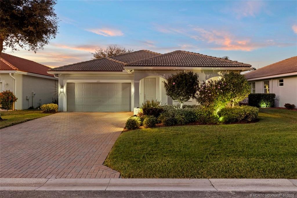 a front view of a house with a yard and garage