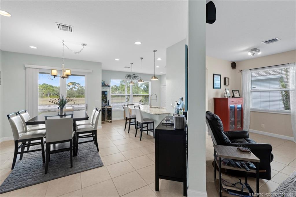 1171 Southeast Kirk Street Stuart, FL 34997 - Photo 16 of 47 a dining room with furniture and a floor to ceiling window