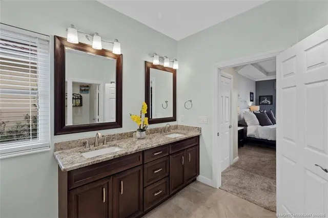 a en suite bathroom with a granite countertop sink and mirror
