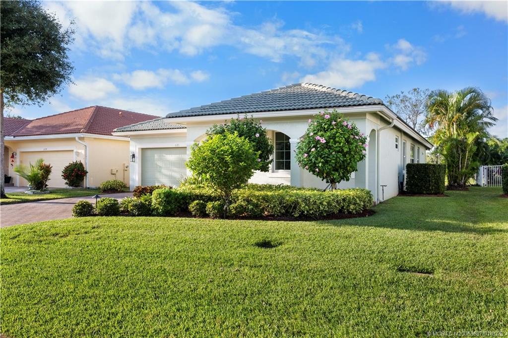 1171 Southeast Kirk Street Stuart, FL 34997 - Photo 3 of 47 a front view of a house with a yard