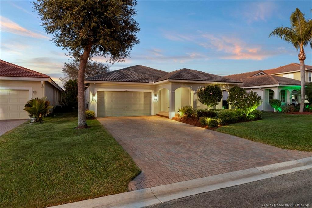 1171 Southeast Kirk Street Stuart, FL 34997 - Photo 5 of 47 a front view of a house with a yard and garage
