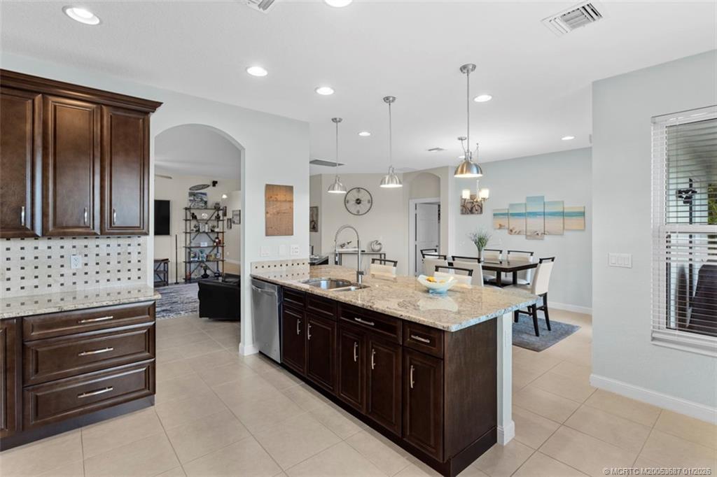 1171 Southeast Kirk Street Stuart, FL 34997 - Photo 8 of 47 a kitchen with kitchen island a sink stove and refrigerator