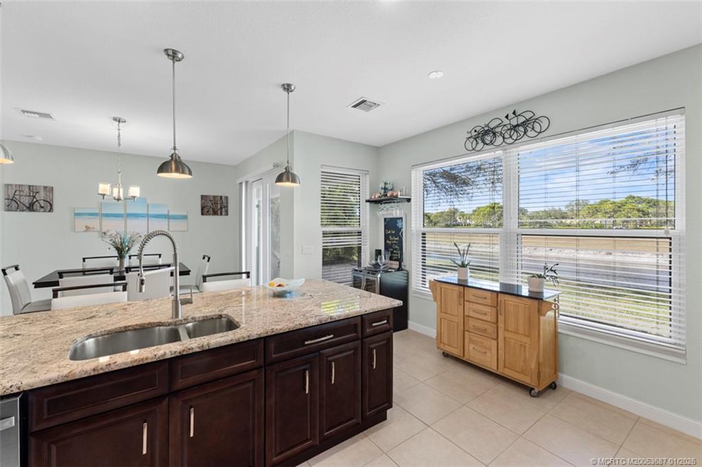 1171 Southeast Kirk Street Stuart, FL 34997 - Photo 9 of 47 a kitchen with kitchen island granite countertop a sink and a stove