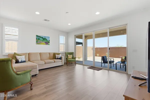 a living room with furniture floor to ceiling window and wooden floor