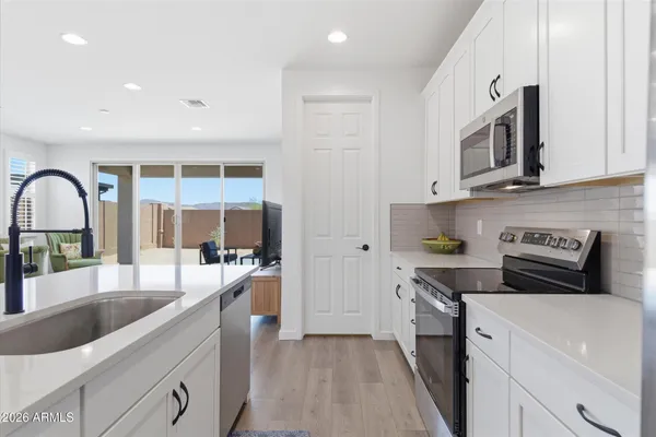 a large kitchen with stainless steel appliances granite countertop a lot of counter space and a sink