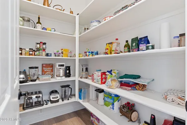 a storage room with lots of clutter and white cabinets